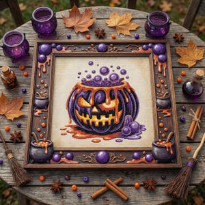 Könnte beinhalten: Ein gerahmtes Halloween-Kreuzstichbild mit einem lila Kürbis mit orangefarbenen Akzenten und einem brodelnden Trank. Der Holzrahmen ist mit dekorativen Elementen verziert. Die Szene spielt auf einem rustikalen Holztisch mit Herbstblättern, Gewürzen und kleinen Kesseln.