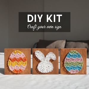 May include: A handmade wooden sign with the text "Welcome" in a handwritten style. The sign is painted white with a distressed finish and features a small, decorative heart. It is designed for indoor or outdoor use.