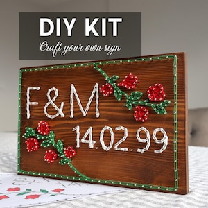 May include: DIY kit for a wooden sign with the text "F&M 14.02.99" in white string. The sign features red roses and green leaves, with a green border and silver nail heads. The top reads "DIY KIT Craft your own sign."