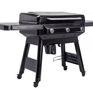 Puede incluir: Una parrilla negra para exteriores con tapa, estantes laterales y perillas de control. La parrilla tiene un asa de acero inoxidable y se asienta sobre un marco de metal negro con ruedas. Los estantes laterales brindan espacio adicional.