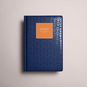 Könnte beinhalten: Ein marineblaues Tagebuch mit silbernem Blumenmuster und einem orangefarbenen quadratischen Etikett. Das Etikett trägt die Aufschrift "DIARY" und "your adventure book" in weißem Text. Das Tagebuch ist geschlossen und hat einen strukturierten Einband.