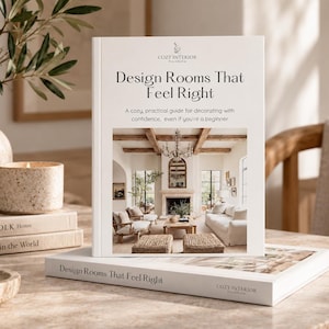 May include: A white hardcover book titled Design Rooms That Feel Right with a subtitle A cozy, practical guide for decorating with confidence, even if you're a beginner. The cover features a photograph of a living room with a fireplace and furniture.