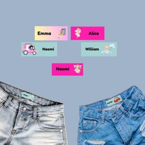 May include: Five rectangular adhesive labels featuring names and illustrations: Emma with a butterfly, Alice with a fairy, Naomi with a car, William with a bear in a car, and Naomi with a fairy. Two pairs of blue denim jeans display these labels.