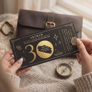 May include: A black and gold birthday scratch card with the name "ARTHUR" and the text "HAPPY 30TH BIRTHDAY". The card features a large gold number "30" and the words "TRIP TO KEFALONIA". A coin is scratching the card to reveal the surprise.