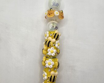 Charakter inspirierter Perlenkugelschreiber mit Hummel-Motiv in gelb, schwarz und weiß. Es hat auch eine Winnie the Pooh Perle.