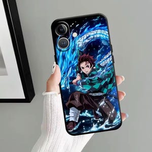 Puede incluir: Funda de teléfono negra con una colorida ilustración de anime. El diseño muestra un personaje con cabello rojo y un atuendo con estampado verde y negro, sobre un fondo de dragón azul y agua. La funda tiene un acabado brillante.