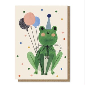 May include: A birthday card with a green frog wearing a party hat and bow tie, holding three balloons. The card has a beige background with colourful polka dots and a brown border.