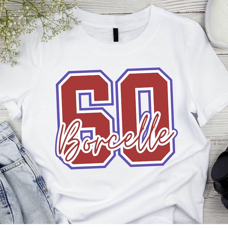 May include: A white short-sleeved t-shirt featuring a large graphic of the number 60 in red with a purple outline. The word Borcelle is written in a white cursive script font across the center of the number 60, also outlined in red.