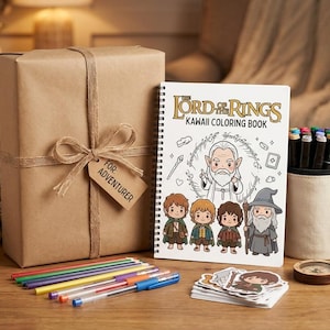 May include: A gift set featuring a wrapped brown box with a tag that reads "For Adventurer", a "Lord of the Rings" Kawaii coloring book, pens, stickers, a mug with markers, a compass, and a small potted plant. The coloring book has illustrations of characters.