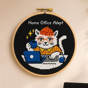 May include: Cross-stitch embroidery in a wooden hoop features a white cat wearing glasses and an orange hat, working on a laptop with a coffee cup. The text "Home Office Adept" is above the cat. The background is black. PDF and SAGA icons are below.