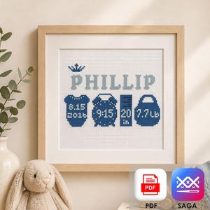 Könnte beinhalten: Ein gerahmtes Kreuzstich-Kunstwerk mit dem Namen "PHILLIP" in Hellblau, mit Geburtsdetails: Datum, Uhrzeit, Länge (50,8 cm) und Gewicht (3,5 kg). Das Design umfasst eine Krone und Baby-Symbole in Marineblau.