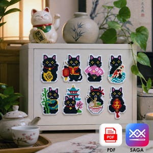 Op de afbeelding: Acht kruissteekpatronen van zwarte katten op een lichtgekleurde kast. Elke kat heeft unieke accessoires zoals een lantaarn, waaier, koikarper, bamboe, pagode, kom ramen en traditionele symbolen, uitgevoerd in levendige, gepixelde kleuren.