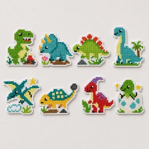 May include: A set of eight pixel-art style dinosaur patches featuring a green T-Rex, a blue triceratops, a green stegosaurus, a blue long-necked dinosaur, a teal pterodactyl, a yellow ankylosaurus, a red parasaurolophus, and a green hatchling.