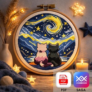 May include: Cross-stitch embroidery in a wooden hoop shows two cats looking at a starry night sky. The design features a swirling yellow and blue sky, with a pink and black cat silhouette. The image includes PDF and SAGA icons.