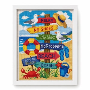 May include: A framed cross-stitch artwork featuring a wooden signpost with directional arrows labeled RELAX, NO SHOES, No Shirt, No Problems, BEACH, I LOVE THE BEACH, and OCEAN. The scene includes a seagull, straw hat, life preserver, flip-flops, crab, and bucket.