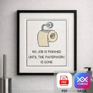 May include: Framed cross-stitch art featuring a toilet paper roll with a humorous message. The text reads, "NO JOB IS FINISHED UNTIL THE PAPERWORK IS DONE." The artwork is in a black frame, suitable for a bathroom or office.