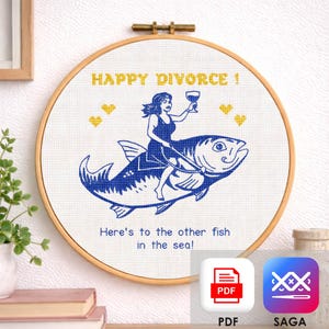 Puede incluir: Un bastidor de bordado de punto de cruz con el texto "HAPPY DIVORCE!" y "Here's to the other fish in the sea!". Una mujer con un vestido azul monta un pez azul, sosteniendo una copa de vino. Corazones amarillos están dispersos alrededor del texto. Incluye iconos PDF y SAGA.