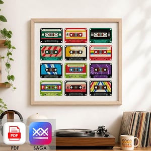 May include: A framed cross-stitch pattern featuring a grid of twelve colourful cassette tapes in various designs, including solid colours, stripes, and rainbow patterns, all displayed on a white fabric background within a light wood frame.