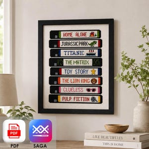 Peut inclure: Une œuvre en point de croix encadrée représentant une pile de huit cassettes VHS noires. Chaque étiquette de cassette affiche un titre de film en lettres brodées : Home Alone, Jurassic Park, Titanic, The Matrix, Toy Story, The Lion King, Clueless et Pulp Fiction.