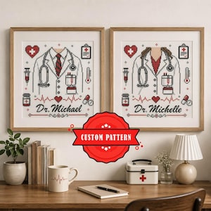 May include: Two framed cross-stitch patterns featuring medical themes. Each shows a white lab coat, stethoscope, heart, and medical icons. One is labeled Dr. Michael and the other Dr. Michelle. The designs include red, black, and white pixelated details.
