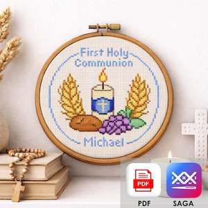 May include: A First Holy Communion cross-stitch embroidery in a wooden hoop. The design features a lit candle, wheat stalks, grapes, and bread. The text reads "First Holy Communion" and the name "Michael".