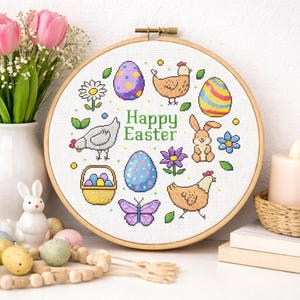 May include: A cross-stitch embroidery hoop with a "Happy Easter" design. The design features colorful Easter eggs, chickens, a bunny, flowers, and a butterfly. The embroidery is set in a wooden hoop, perfect for Easter decor.