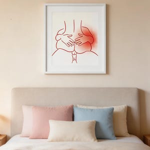 May include: A framed art print featuring a red line drawing of two figures embracing. The artwork is displayed above a bed with pink, blue, and cream-colored pillows. The bedspread is a soft pink.