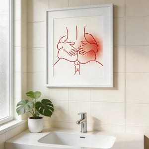 May include: A framed art print featuring a minimalist line drawing in red of a person's back and hands. The artwork is displayed in a white frame against a white background. The image is in a bathroom setting with a sink and a potted plant.