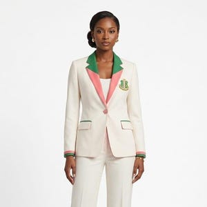 Peut inclure: Un blazer couleur crème doté d'un revers cranté avec des bordures contrastantes vertes et roses. La veste comprend une fermeture à un bouton, deux poches à rabat avec passepoil vert et un écusson brodé doré sur la poitrine gauche. Les manches ont des poignets rayés.