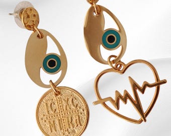 May include: Gold-toned earrings with a unique design. Each earring features a textured stud, an oval charm with a blue and black eye, and a dangling element. One earring has a coin pendant, the other a heart with a heartbeat line.