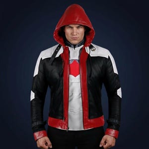 May include: A black, white, and red hooded jacket with a zipper closure. The jacket features a red hood, white accents on the shoulders and sleeves, and a red chest emblem. The jacket is made of a leather-like material.