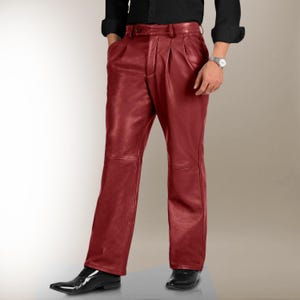 May include: Deep red leather trousers featuring a high-waisted design with front pleats, a button and zip closure, and a straight-leg cut. The trousers have a smooth, polished finish and are worn with a black shirt and black dress shoes.