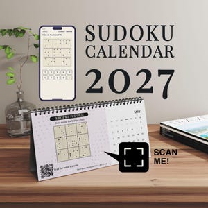 Puede incluir: Un calendario de Sudoku 2027 con encuadernación en espiral, que presenta un rompecabezas de Kropki Sudoku para mayo, un código QR y un icono de scan me. Arriba, un teléfono inteligente muestra un Sudoku clásico. El texto dice Sudoku Calendar 2027.