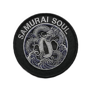 May include: Round black patch with the words "SAMURAI SOUL" in white lettering. The patch features a detailed silver dragon design with blue accents, a sword, and waves.