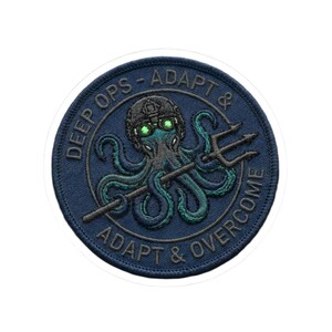 May include: Circular embroidered patch with a navy blue background and white border. The design features an octopus wearing a helmet and holding a trident. The text "DEEP OPS - ADAPT & ADAPT & OVERCOME" is embroidered around the octopus.