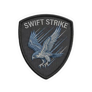 May include: Embroidered patch with a shield shape and a white border. The patch features a blue and white falcon in flight with the text "SWIFT STRIKE" in white.