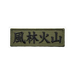 May include: Olive green embroidered patch with black Japanese characters. The rectangular patch has a white border and is likely designed to be sewn onto clothing or gear. The text is in a bold, stylized font.