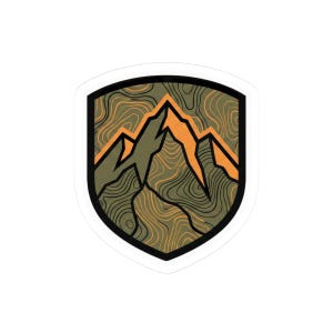 May include: A sticker featuring a mountain range design. The mountains are orange and green, set against a topographic map background. The sticker has a black border and a white outline, giving it a shield-like shape.
