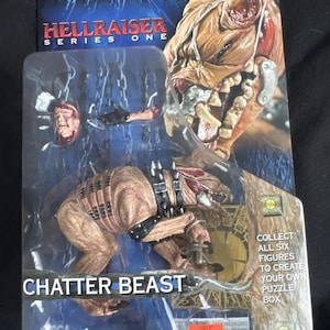 May include: A Hellraiser Series One action figure of the Chatter Beast, packaged on a blue and black card. The figure is brown with black accents and a spiked collar. The packaging includes the text "Collect all six figures to create your own puzzle box."