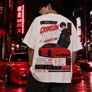 Könnte beinhalten: Weißes T-Shirt mit einer Grafik eines roten Sportwagens und den Worten "CRIMSON DRIFT" in Rot. Das Shirt hat auch japanischen Text und den Text "180SX S13". Das Shirt hat eine Streetwear-Ästhetik.