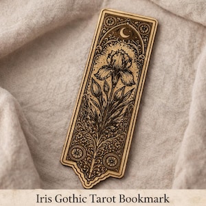 May include: A wooden bookmark with an engraved iris flower design, a crescent moon, and ornate gothic details. The bookmark is rectangular with a decorative bottom edge. The text "Iris Gothic Tarot Bookmark" is at the bottom.