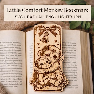 May include: Wooden bookmark featuring a detailed engraving of two monkeys embracing, with a bow and tassel at the top. The bookmark is set against an open book. Text on the bookmark reads "Little Comfort Monkey Bookmark".