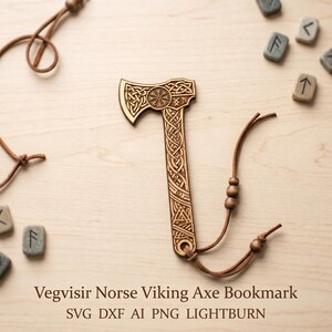 May include: A wooden axe-shaped bookmark with intricate Celtic knotwork and a Vegvisir symbol. The bookmark has a leather cord attached. The text "Vegvisir Norse Viking Axe Bookmark" is at the bottom. Runes are scattered around the bookmark.