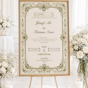 May include: A rectangular wedding sign in a gold frame on a gold easel, featuring a cream background with a green floral border. The text includes the names Yusuf Ali and Fatima Noor, the date January 25, and the location Al Rahman Event Hall.