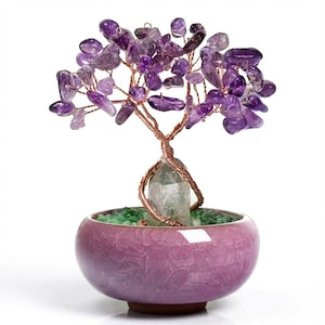 May include: A decorative amethyst gemstone tree sculpture. The tree has a copper wire trunk and branches, with amethyst chips forming the leaves. It sits in a crackled purple ceramic pot filled with green stones, against a white background.