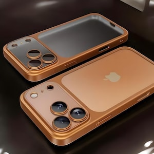 Op de afbeelding: Twee bronskleurige telefoonhoesjes. De hoesjes hebben een doorzichtige achterkant met het Apple-logo en een beschermer voor de cameralens. De cameralensbeschermer heeft drie cirkelvormige uitsparingen voor de lenzen. De hoesjes zijn van metaal.