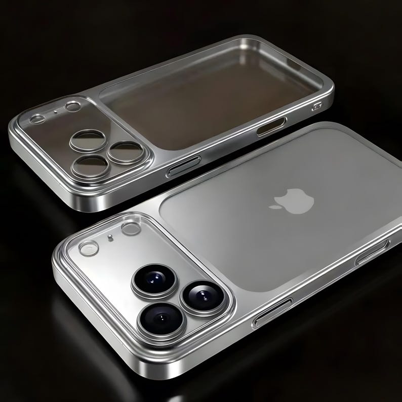 Op de afbeelding: Twee zilveren telefoonhoesjes met een doorzichtige achterkant en een zilveren frame. De hoesjes hebben een camera-uitsparing met drie lenzen en een doorzichtig gedeelte voor het scherm. Het Apple-logo is zichtbaar op de achterkant van &eacute;&eacute;n hoesje.