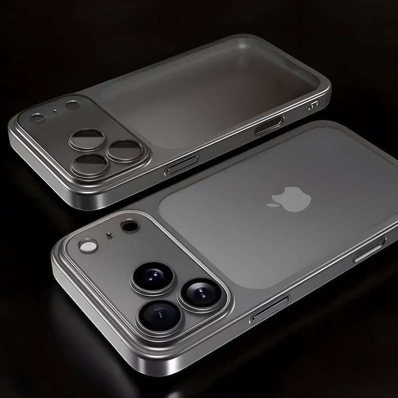Op de afbeelding: Twee grijze telefoonhoesjes met een metalen frame en een doorzichtige achterkant. De hoesjes hebben een camera-uitsparing met drie lenzen en een zijknop. E&eacute;n hoesje heeft het Apple-logo op de achterkant.