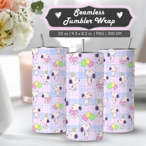 May include: Three tumblers with a repeating pattern of Snoopy characters, hearts, and balloons on a light blue and pink plaid background. The tumblers have a silver straw and are approximately 23.6 cm tall.