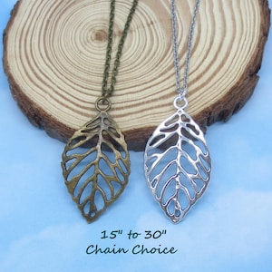 May include: Two leaf pendant necklaces. One is bronze-toned, the other silver-toned. The leaf pendants are open-worked. The chains are available in 15 to 30 inches.